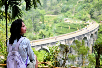 Woman enjoying a view over Nine Arches bridge in Demodara one of the iconic landmarks in Sri Lanka