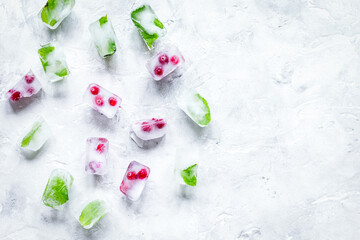 Obraz na płótnie Canvas frozen red berries in ice cubes on stone background space for text top view