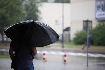 man with umbrella in rain, Poland