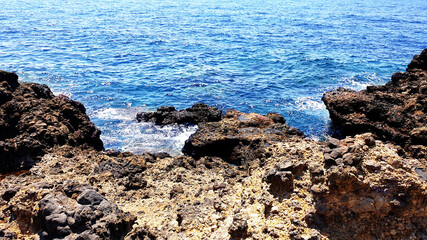 Blue sea and rocks beach background. Aqua sea water surface. Sea surface view.