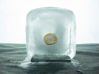 Coin stuck inside an ice cube, economy stopped, European economic crisis, euro coin inside ice,...