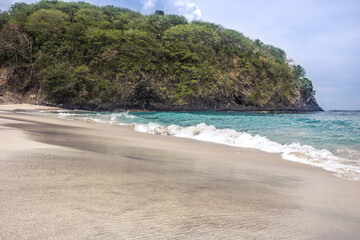 Bali beach named White sand virgin Beach with turquoise sea water waves blue sky 