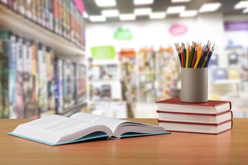 Stack school books with colorful pencils on a desk