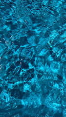 Soft focus background. Swimming pool water texture in abstract style on blue background. Vacation, holiday. Ripple water. Swimming pool water sun reflection background. Summer vacation.