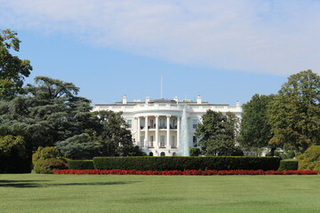 Back facade and backyard of the White House, official house of the president of the United States, on a summer day with blue sky.