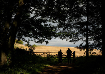 Silhouette of two walkers on footpath on Bredon Hill, Kemerton, Pershore, Worcestershire England UK
