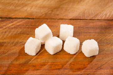 Refined sugar cubes on wooden background