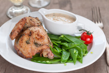 Half Roasted Chicken with Sugar Snap Peas as Side Dish and Cream Sauce