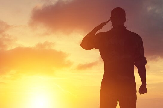 Young military soldier man silhouette on sunset background