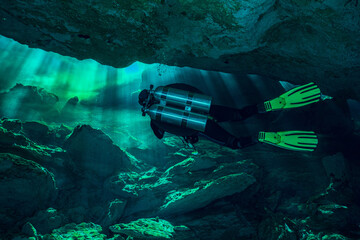 Cave Diver with Double Tank Diving in Ray of Lights