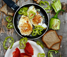 A simple breakfast on the mountain. Traditional healthy easy quick breakfast meal made of two fried eggs served on a frying pan. International simple food, top view.