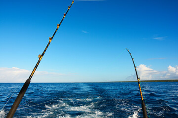 Fototapeta premium Two fishing rods on a boat in the ocean