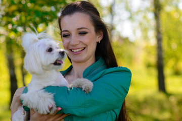 Young girl with her dog. Puppy white dog is running with it's owner. Concept about friendship, animal and freedom.