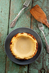 Homemade cheesecake on the old painted wood with wooden spatula