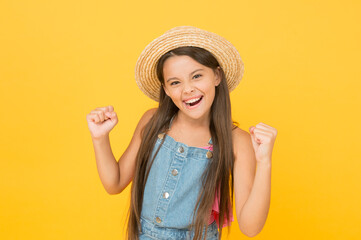 Spending great summer time. joyful summer holiday and vacation. kid seasonal fashion. carefree beauty at yellow wall. smiling kid in straw hat. little child ready for beach activity. happy childhood