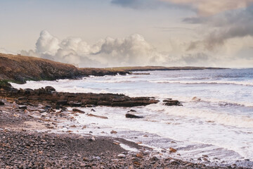 Rosses point beach in county Sligo, Ireland. Warm sunny day, Cloudy sky, Nobody, waves in the ocean water, Calm and tranquill scene.