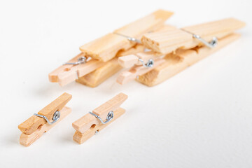 Small and large wooden clothes pegs. Household accessories. White background.