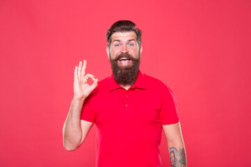 Fototapeta premium Best haircut here. Promoting barber services. Portrait of bearded man red background. Brutal guy with mustache. Hipster with beard. Hairdresser salon. Brutality and confidence. Barbershop model