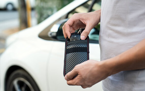 Man using RFID protection pouch for car key, anti-theft RFID key pouch.