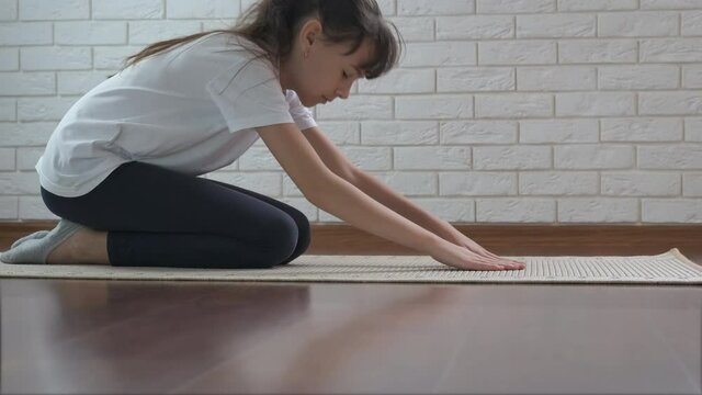 Relaxing the back muscles. Young girl doing yoga for the back.