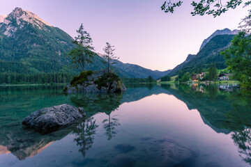 Beautiful scene of trees on a rock island and mountains at sunset time in summer, Lake Hintersee National park Berchtesgadener Land, Upper Bavaria, Germany, Europe