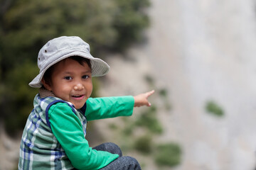 Young latino boy in awe after spotting elusive wildlife in Southern California mountains.