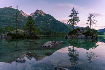 Beautiful scene of trees on a rock island and mountains at sunset time in summer, Lake Hintersee National park Berchtesgadener Land, Upper Bavaria, Germany, Europe