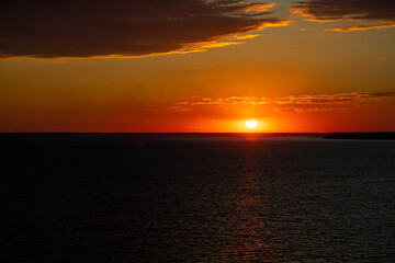 Beautiful sunset above the sea. Idyllic shot of sunset by the sea waters, warm orange and red colors