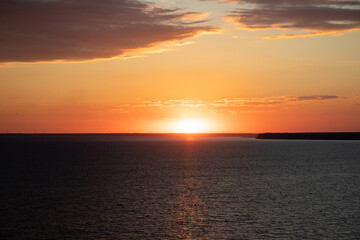 Beautiful sunset above the sea. Idyllic shot of sunset by the sea waters, warm orange and red colors