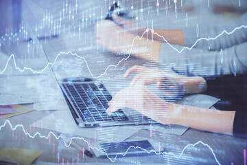 Multi exposure of woman hands typing on computer and financial chart hologram drawing. Stock market...