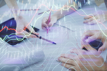 Double exposure of forex graph drawing and man and woman working together holding and using a mobile device. Trade concept.