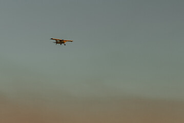 Plane in the sky flying over dust clouds