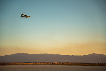Obraz na płótnie Canvas Plane in the sky flying over dust clouds