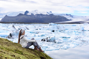 Iceland tourist enjoying Jokulsarlon glacial lagoon. Woman visiting destination landmark attraction...