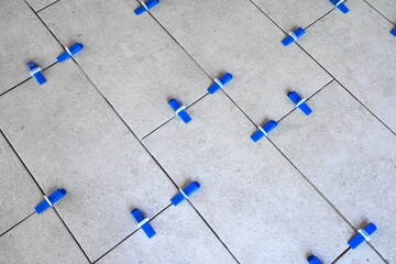 Industrial background. Tile leveling system with plastic clips and wedges, 