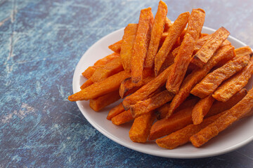 Plate of Sweet Potatoe Fries on a Blue Wooden Table