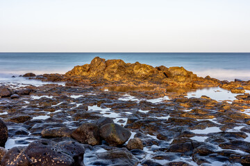 Foreground of rocks on the urban beach of Puerto del Rosario on the island of Fuerteventura, Canary Islands, with low tide