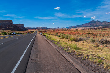 Classic panorama view of an endless straight road running through the barren scenery of the American Southwest.
