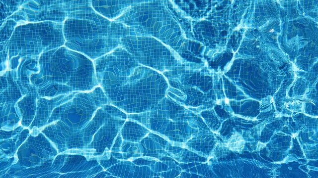 Aerial top down view of swimming pool water surface. The camera flies over the water