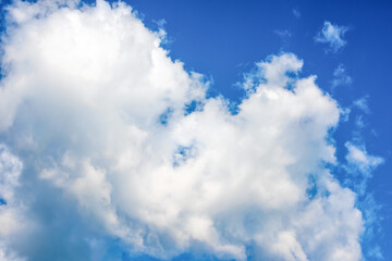 Naklejka na ściany i meble Fluffy white clouds on background of blue sky. Wallpaper.