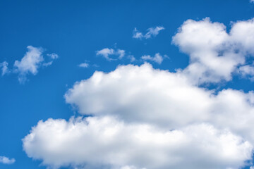 Fluffy white clouds on background of blue sky. Wallpaper.