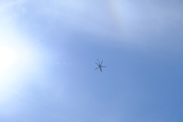 晴れの空の真上を飛行するヘリコプター