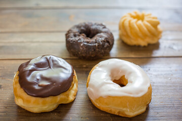 Bakery fresh doughnuts soft and sweet delicious glazed frosted donuts variety on wood table surface