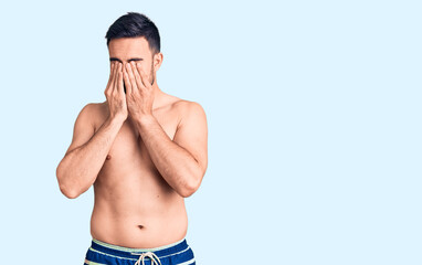 Fototapeta premium Young handsome man wearing swimwear rubbing eyes for fatigue and headache, sleepy and tired expression. vision problem