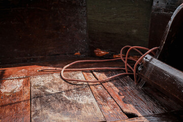 Close up rope with light and shadow on old wooden fishing boat in Thailand copy space can be used for travel or adventure concept.
