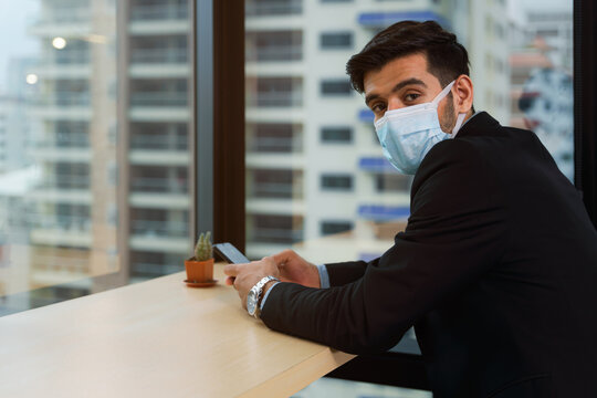 businessman wear face mask using smartphone in office