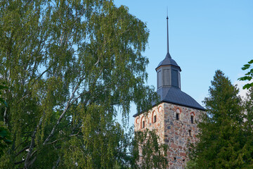 A clocktower of Korppoo Church in Parainen, Finland against a blue sky with clouds. Copy space.