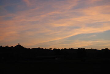 Sunrise Over Glastonbury Skyline Silhouette with Tor Orange Clouds Vivid Color Rural Countryside