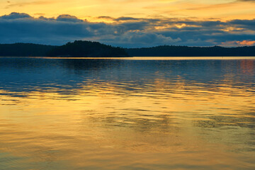 Fototapeta na wymiar A colofrul sunset with reflections on water in an archipelago in Parainen, Finland.