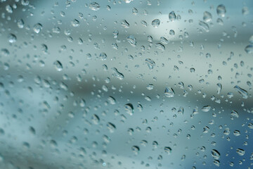 Rain drops on a glass window as an abstract blurred background. Selective focus.